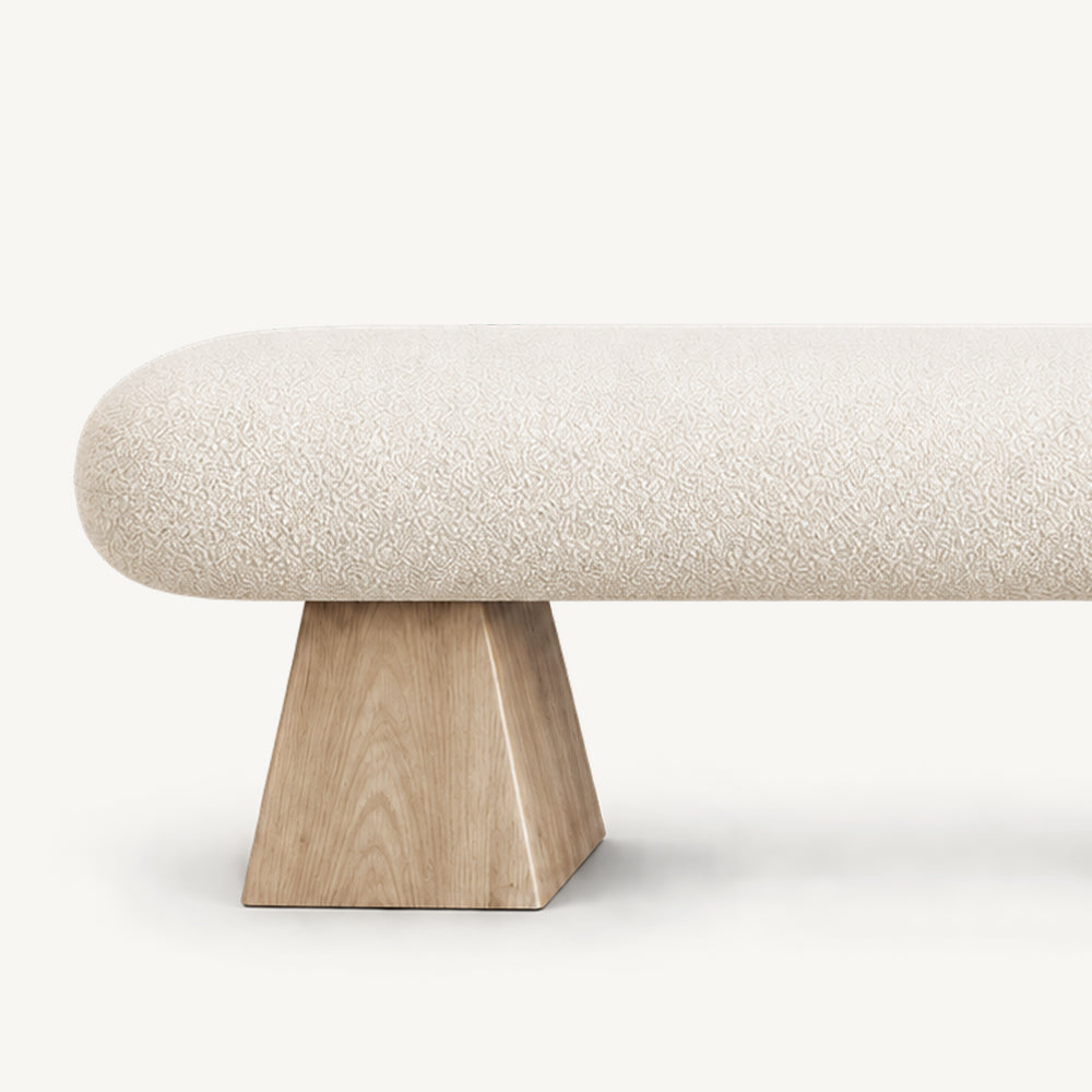 Close-up of the cream bench seat above its light wood-tone tapered block support.