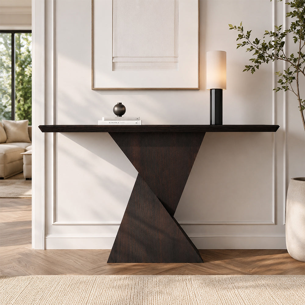 Front view of the dark wood-tone console table with a sculptural crossed-panel base.