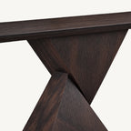 Close-up of the geometric console pedestal where its two angled panels cross beneath the top.