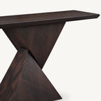 Close-up of the dark console table's top and angular pedestal.