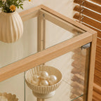 Overhead detail of the display cabinet's glass top and light wood-tone corner frame.