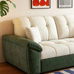 Detail of the sofa bed's cream tufted back cushions and dark green padded arm.