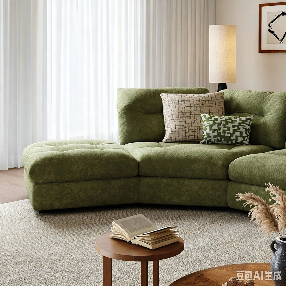 Front detail of the green sofa's extended end seat and tufted back cushions.