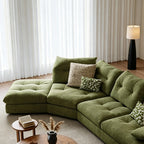 Overhead detail of the green sectional sofa's corner and tufted seat modules.