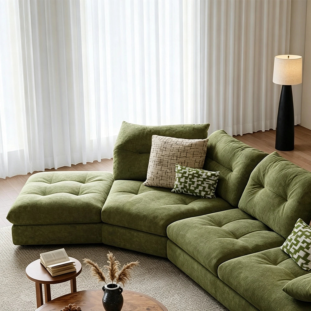 Overhead detail of the green sectional sofa's corner and tufted seat modules.