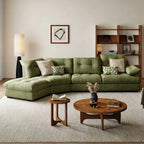 Green tufted sectional sofa with a curved arrangement and extended end seat in a bright living room.