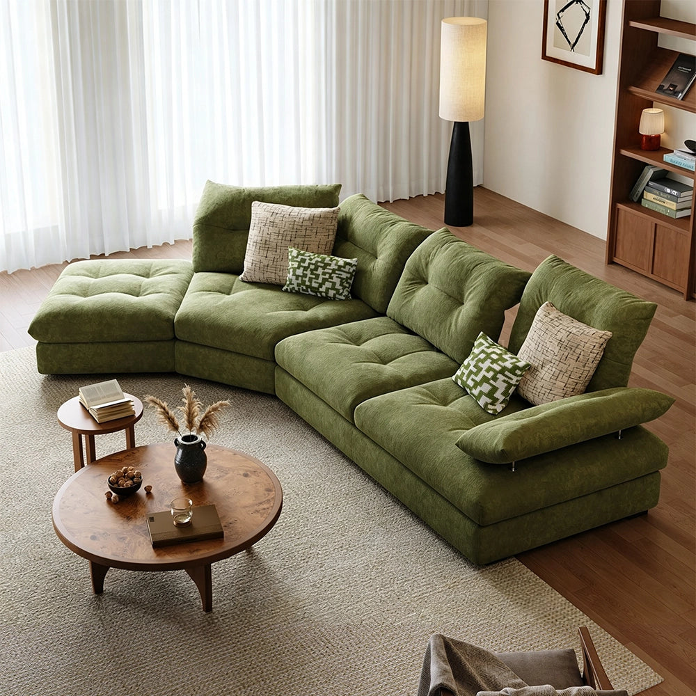 Overhead angled view of the green sectional sofa, tufted seat cushions and patterned pillows.
