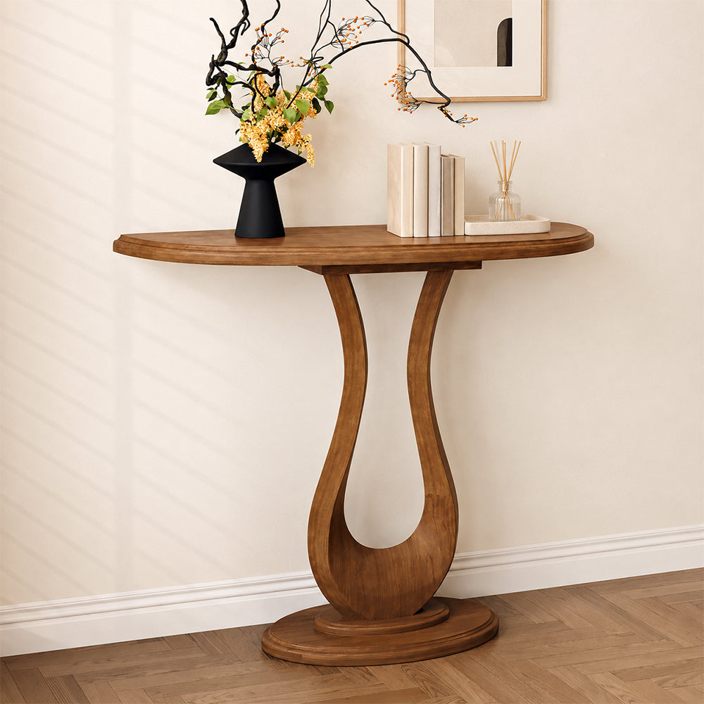 Angled view of the half-moon console table against a pale wall, with an oval base.