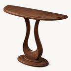 Brown wood-tone half-moon console table with an open sculptural pedestal and oval foot.