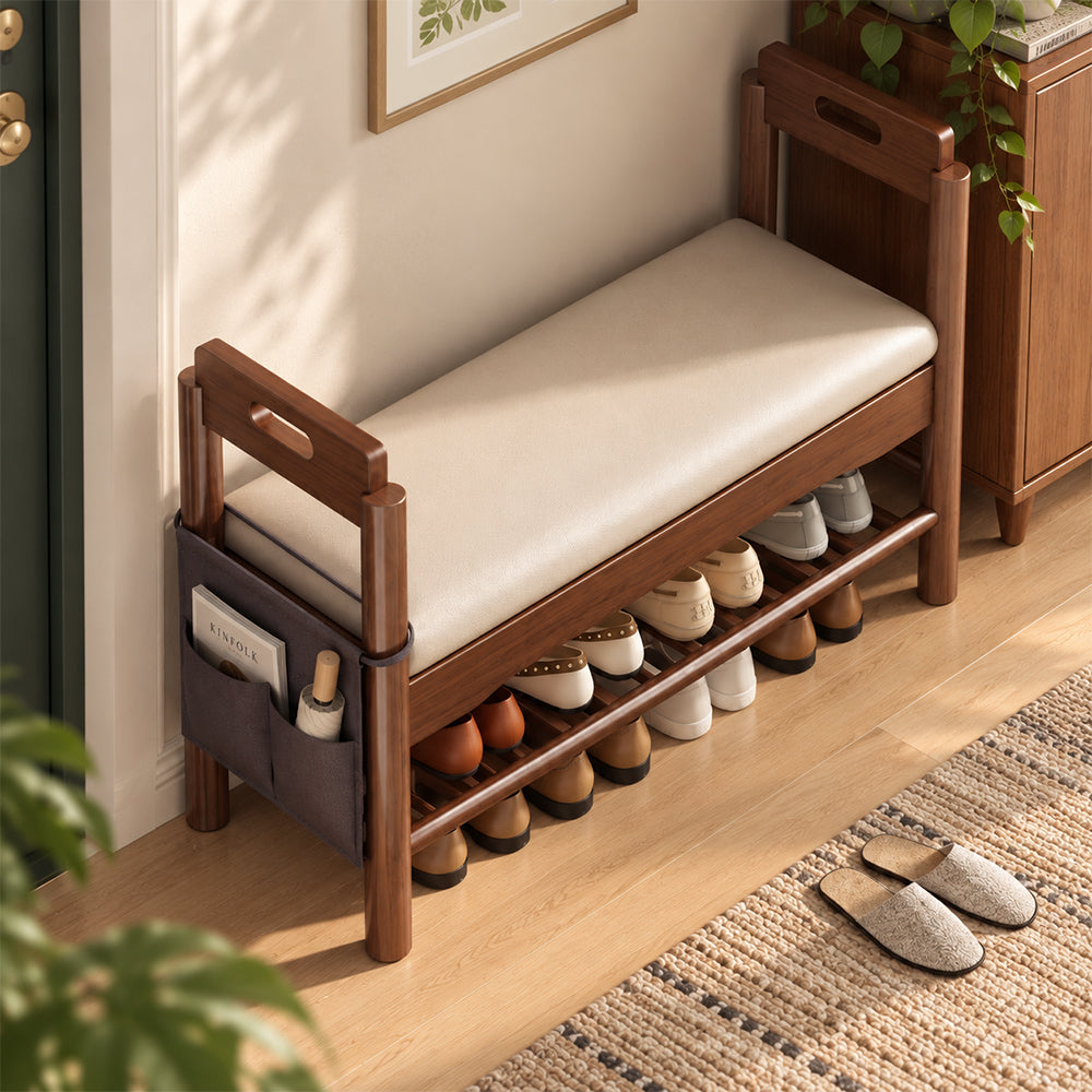 Overhead angled view of the cream-cushioned shoe bench with brown arm supports and shoes stored below.