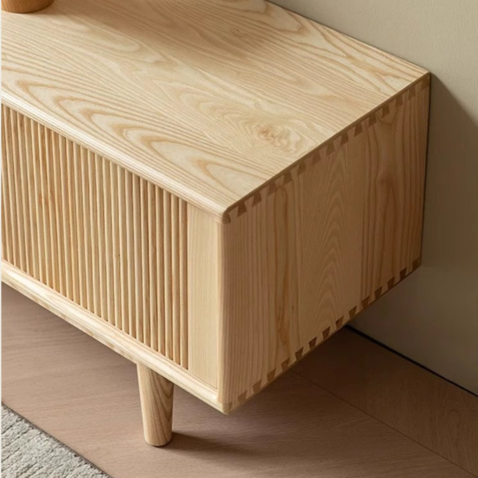 Close-up of the media console's wood-grain top, fluted front and visible corner joints.