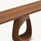 Close-up of the console table's wood-grain tabletop and the top of its loop-shaped pedestal.