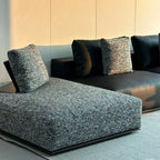 Close-up of the sofa's gray textured chaise beside dark smooth seat modules.
