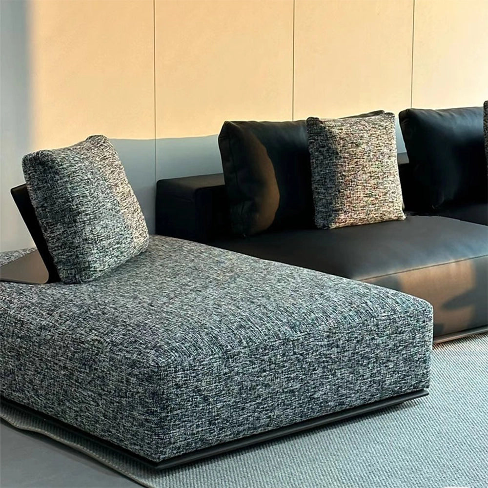 Close-up of the sofa's gray textured chaise beside dark smooth seat modules.