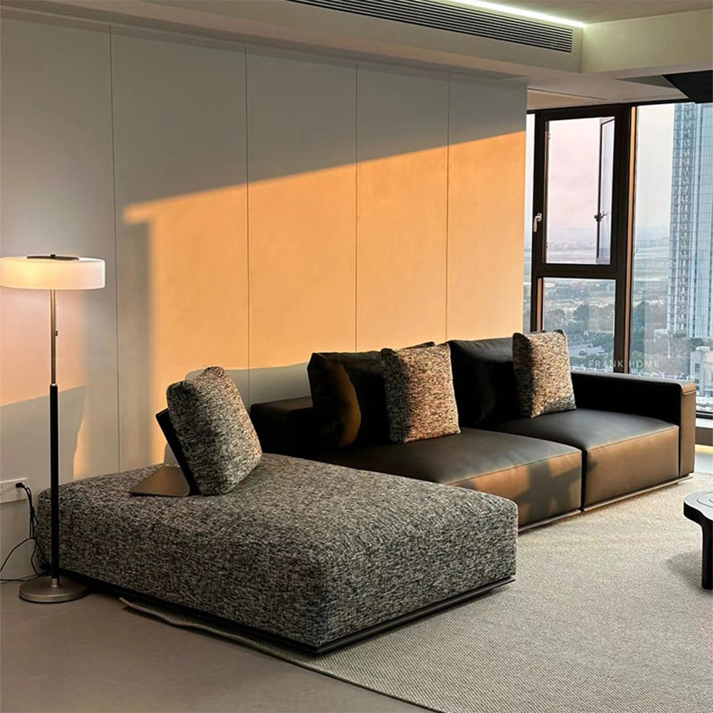 Low modular sofa with dark smooth seat modules and a gray textured chaise on the left as pictured.