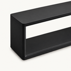 Detail of the black bench's outer side panel and rounded top corner.