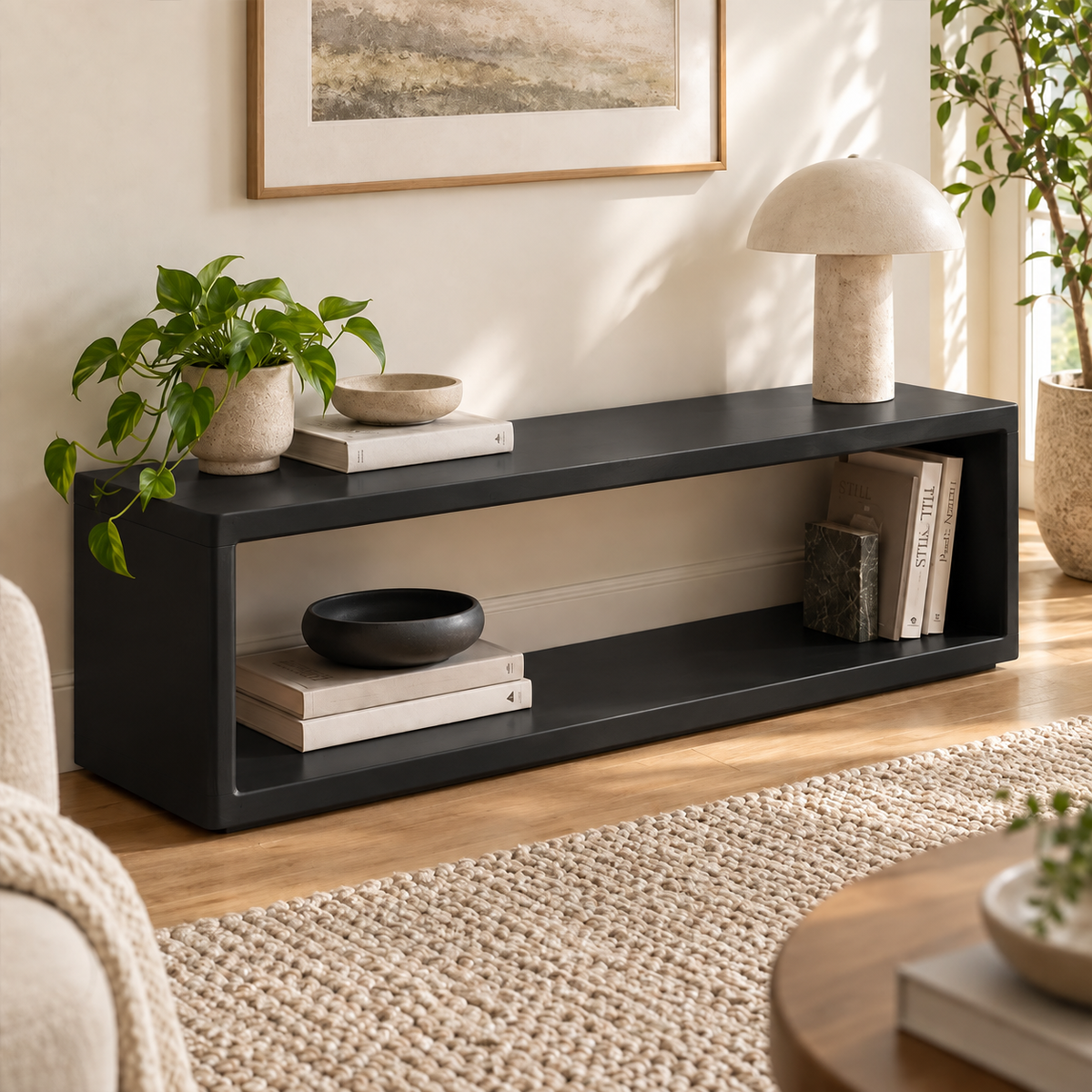 Black open-frame bench with a long lower shelf, styled beside plants and a floor lamp.