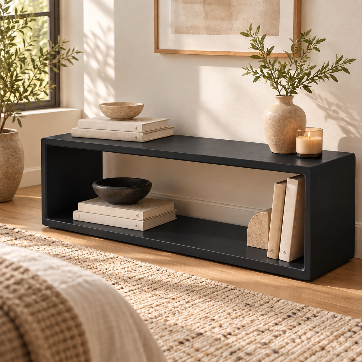 Angled view of the black open-frame bench with books and a vase on top.
