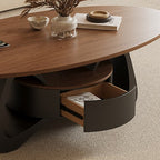 Close-up of the oval coffee table's open curved-front drawer with a magazine inside.