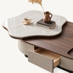 Open drawer beneath the oval coffee table's brown surface and raised white veined tabletop.