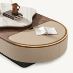 Close-up of the oval coffee table's beige inset surface with its surrounding rim illuminated.