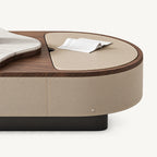 Detail of the coffee table's beige inset top, brown rim and stitched side panel.