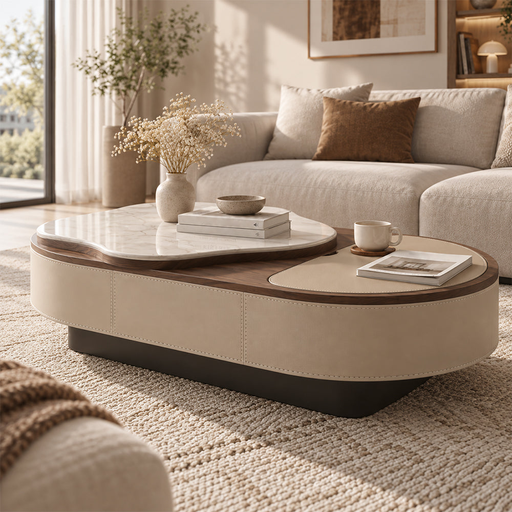 Angled room view of the oval coffee table with a raised white veined top and beige inset surface.