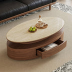 Overhead view of the light-topped oval coffee table with its drawer open beside a black sofa.