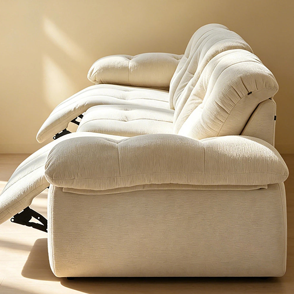 Side view of the cream reclining sofa showing its pillow arm and extended footrest mechanism.