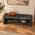 Overhead angled view of the black bench's stitched cushion, broad side supports and shoe shelf.