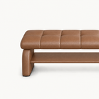 Close-up of the brown bench's stitched cushion, left side support and lower storage shelf.