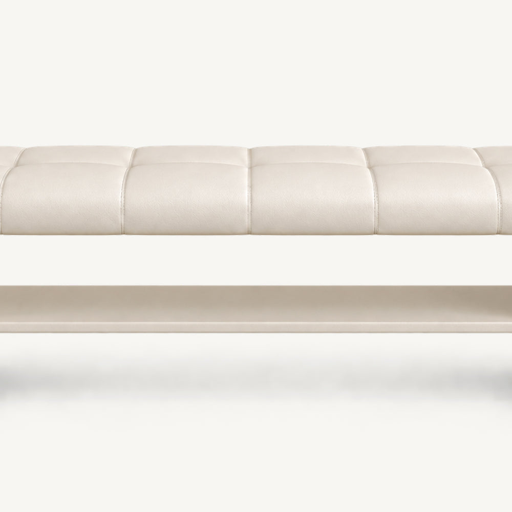 Front detail of the cream bench's stitched seat and long open shelf beneath it.