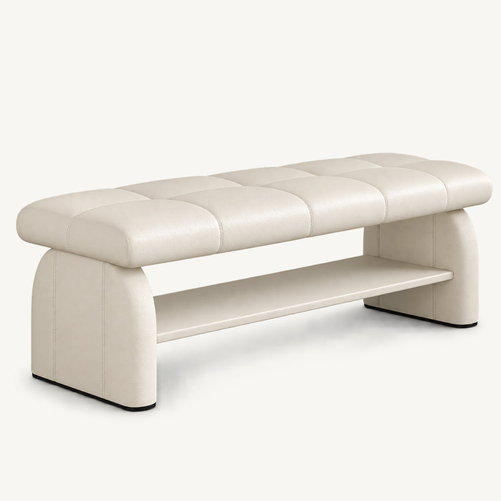 cream upholstered bench with a rectangular stitched seat, rounded side supports and an open lower shelf.