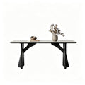 Pale rectangular dining table with black sculptural supports and curved braces on a white background.