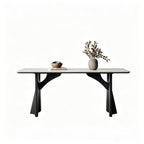 Pale rectangular dining table with black sculptural supports and curved braces on a white background.