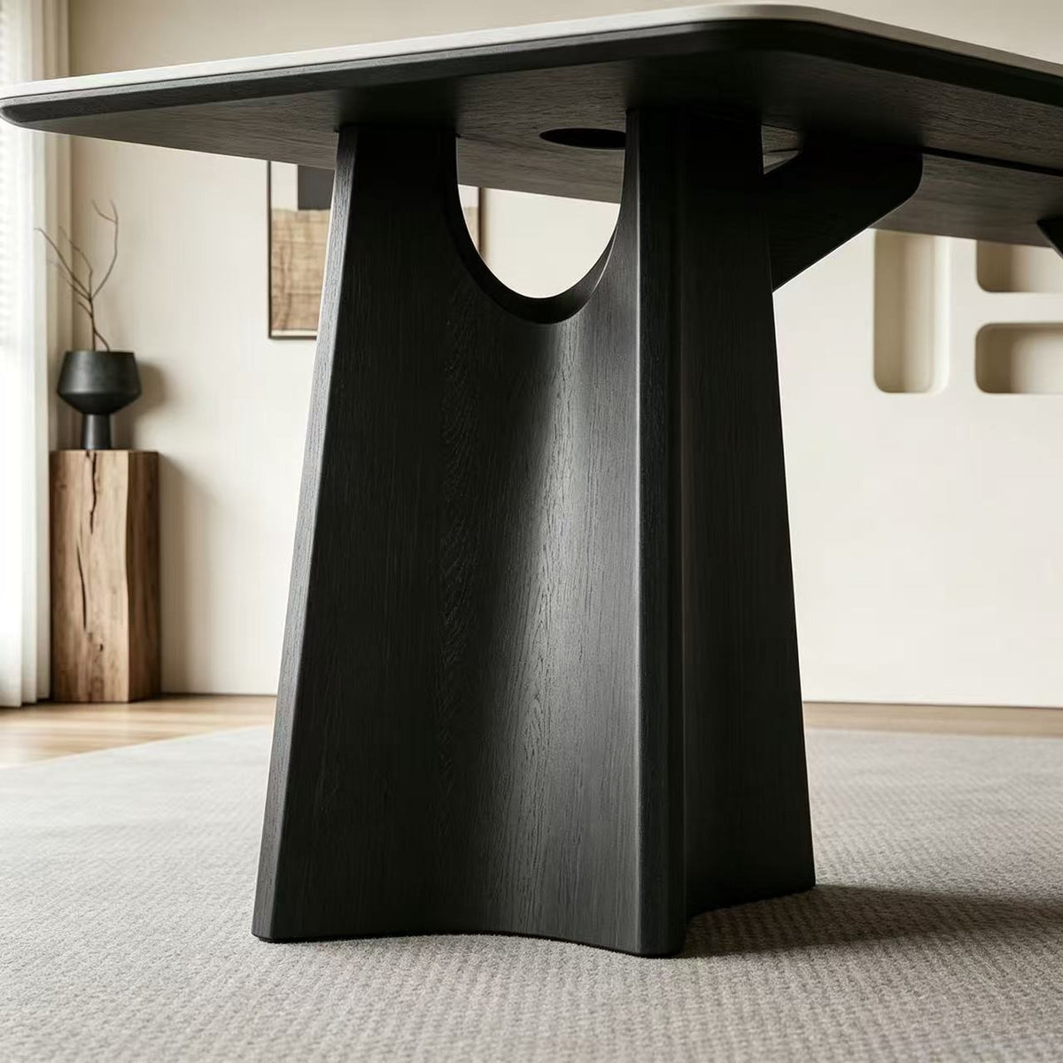 Close-up of the dining table's black flared support and curved opening beneath the tabletop.