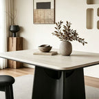 Angled close-up of the dining table's pale rounded-corner top and curved black support.