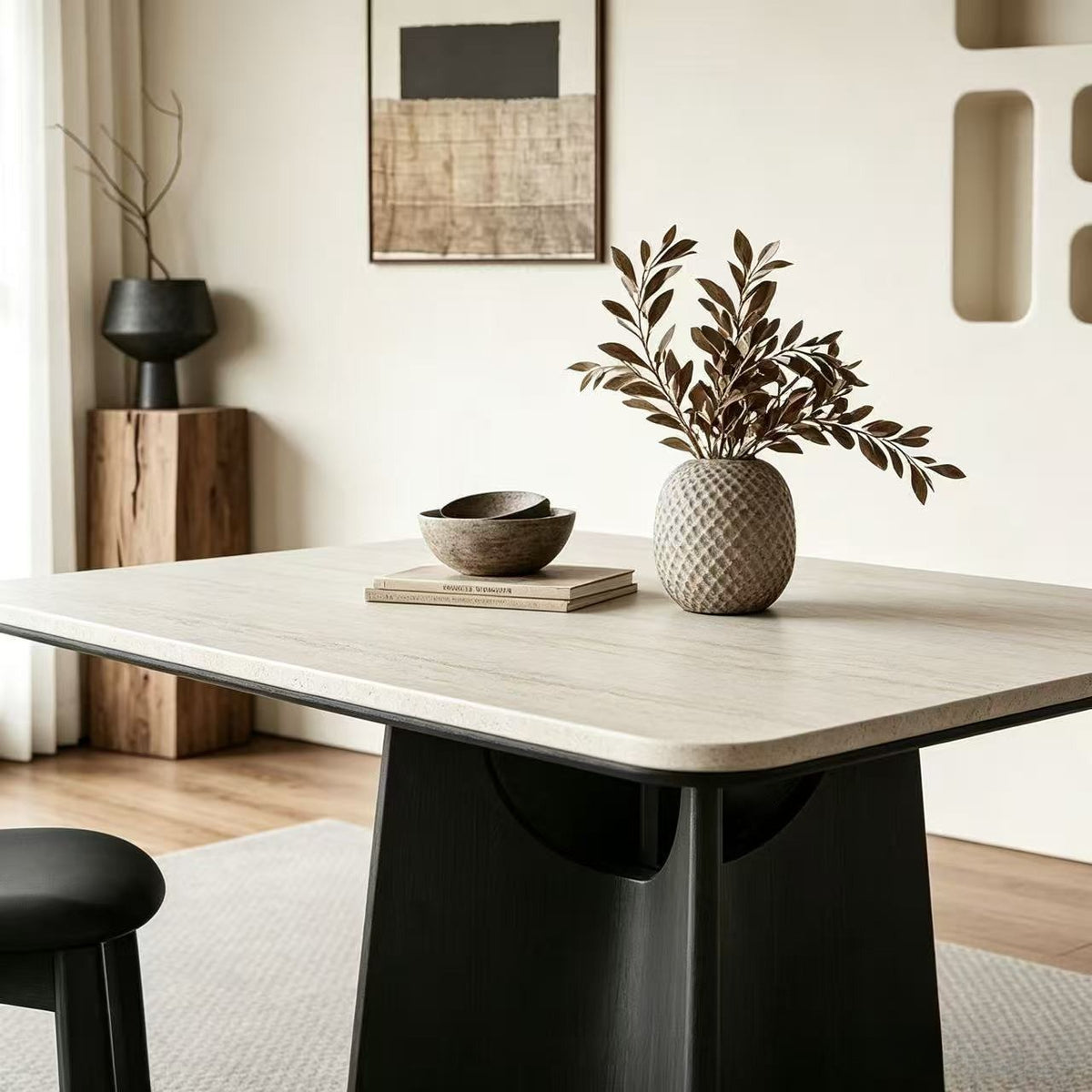 Angled close-up of the dining table's pale rounded-corner top and curved black support.
