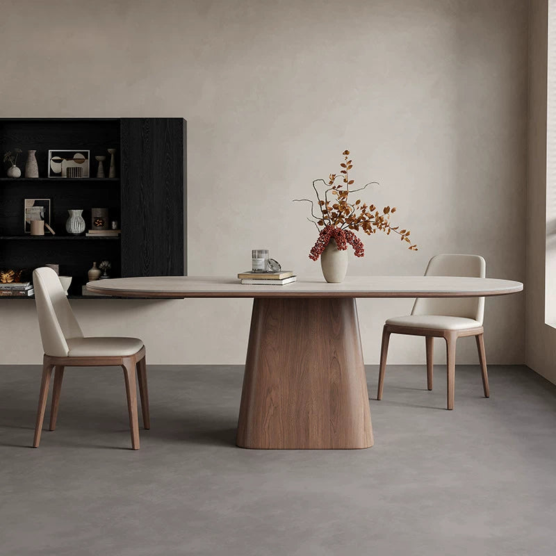 Side view of the oval dining table showing its slim pale top and wide tapered brown pedestal.