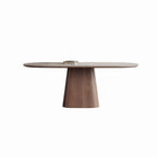 Oval pale-top dining table with a single broad tapered wood-tone pedestal on a white background.