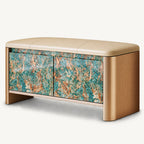 Beige upholstered storage bench with rounded gold-tone sides and two turquoise and brown patterned cabinet doors.