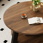 Overhead close-up of the coffee table's brown grain-patterned top with a cup, open book and flowers.
