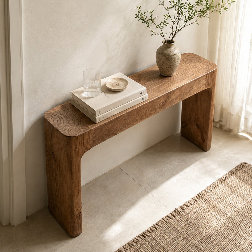 Overhead angled view of the brown console table's narrow top and rounded slab sides.