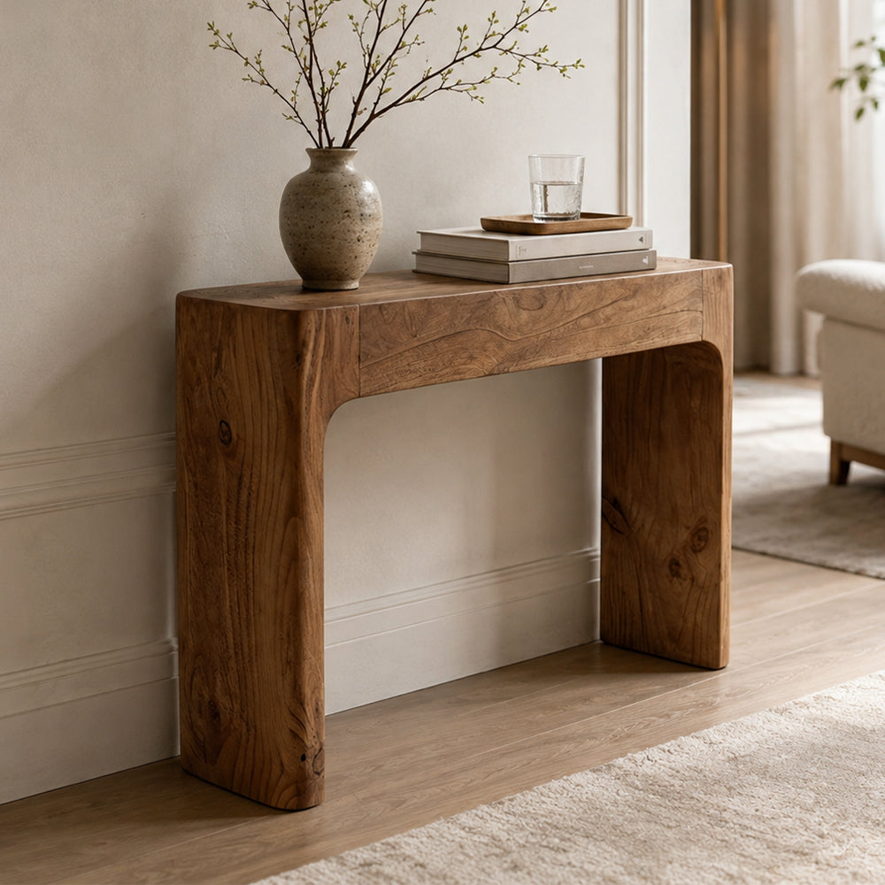 Angled entryway view of the brown console table with a continuous rounded frame.