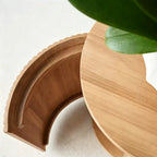 Curved cabinet door open at the rounded end of the ribbed-front TV stand.