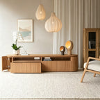 Rounded wood-tone TV stand with a cabinet door and drawer open to show the storage compartments.