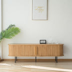 Light wood-tone TV stand with rounded ends, vertical slatted doors and slim black legs.