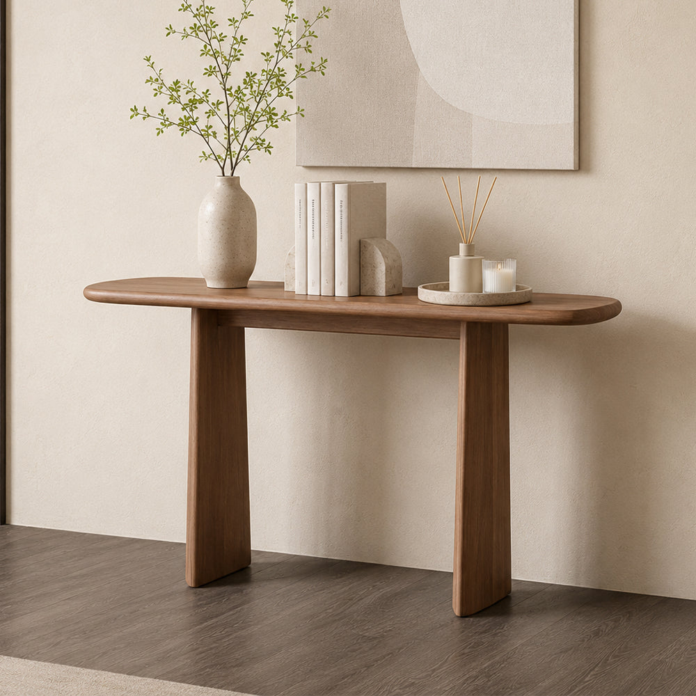 Brown version of the rounded-top console table with two tapered legs, styled against a pale wall.