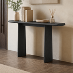 Dark wood-tone console table against a pale wall, with a long rounded top over two panel legs.