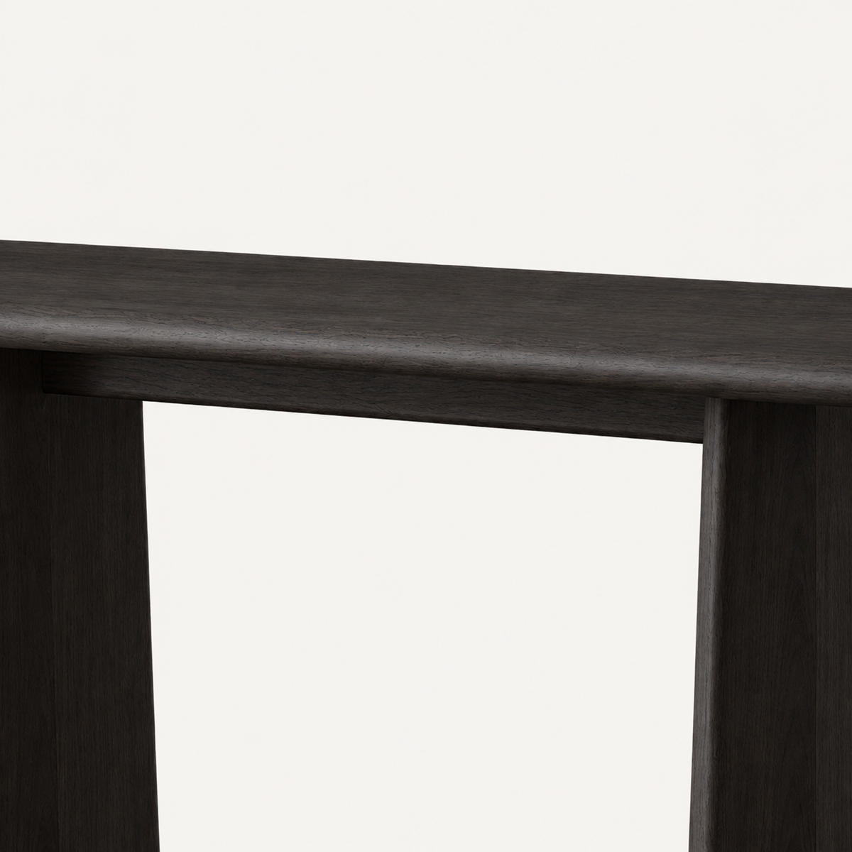 Front detail of the dark console table's smooth rounded top edge and two panel legs.